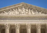 Detailed view of the Supreme Court Building's frontal frieze depicting historical figures and justices.