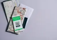 A health passport for COVID-19 displayed on a smartphone alongside travel documents.