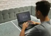 A man working on a laptop in a cozy, modern office space with a focus on technology.
