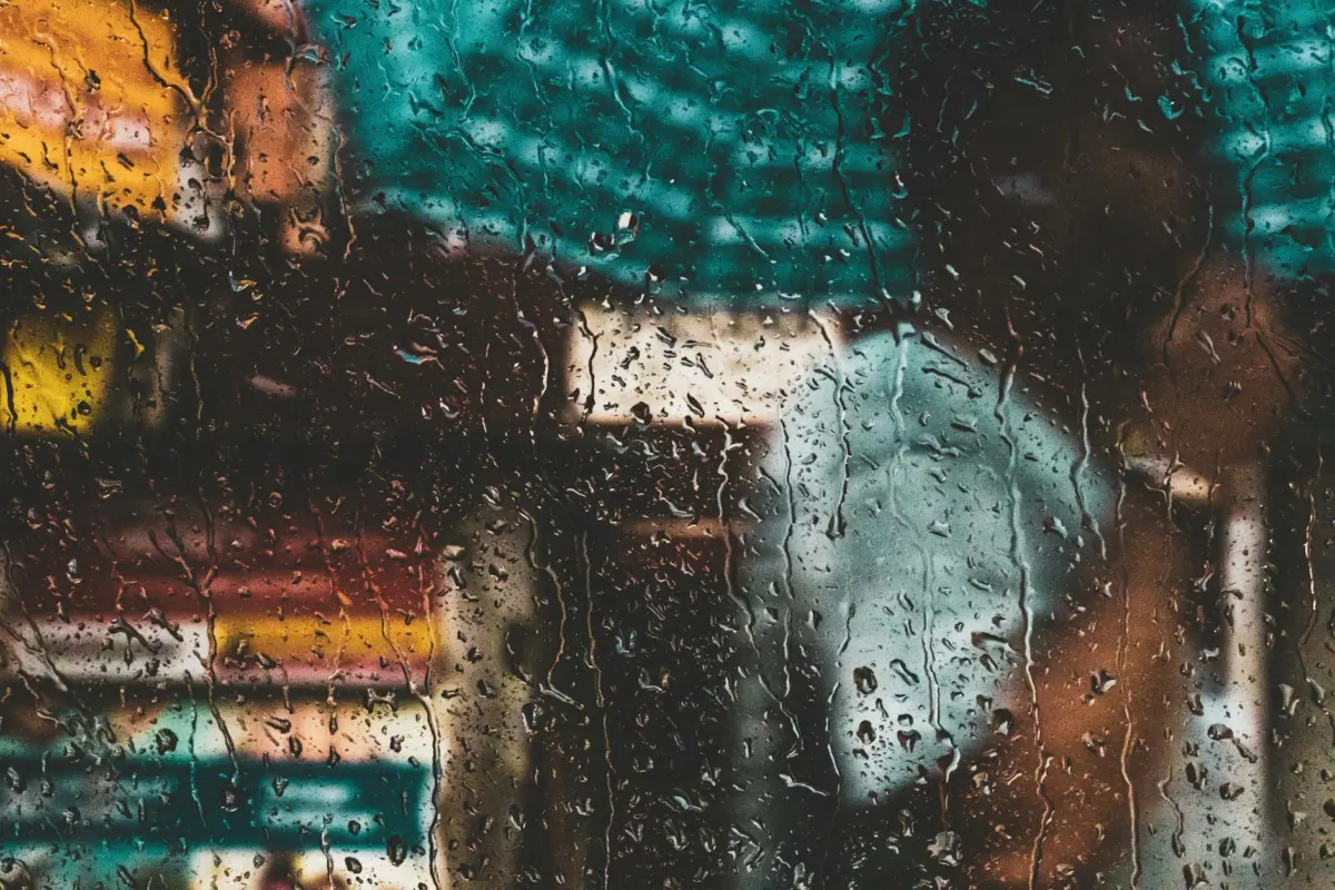 Blurred view through a rain-soaked window capturing the vibrant essence of Kolkata's streets.