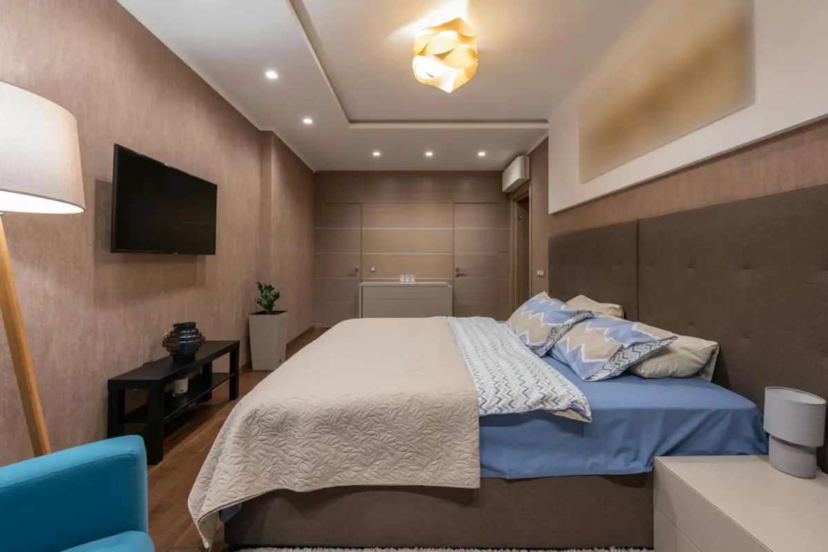 बेडरूम वास्तु के 12 नियम — दिशा, बिस्तर, रंग और आईने का सही स्थान 2 Elegant modern bedroom featuring a stylish bed, ambient lighting, and cozy decor.