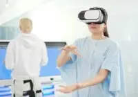 Woman in VR headset interacting in a modern office with tech devices in the background.
