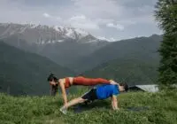 A couple working out outdoors in a picturesque mountain landscape, showcasing fitness and healthy lifestyle.