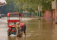 A rickshaw navigates a flooded street in New Delhi, India, during the 2023 monsoon.