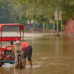A rickshaw navigates a flooded street in New Delhi, India, during the 2023 monsoon.