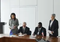 Business leaders signing a significant agreement in a conference room setting.