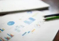 Illustration of a business financial report featuring various charts and graphs on paper.