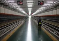 Long hallway in Indian textile factory with spinning machinery and workers.