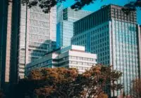 View of modern skyscrapers in Tokyo's bustling financial district with clear blue sky.