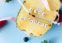 Flat lay of pineapple, syringe, and message promoting anti-diabetes awareness.