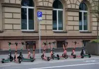 Row of electric scooters parked on a street in downtown Frankfurt, Germany.